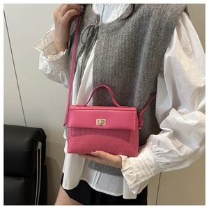 Detailed view of a pink mini handbag featuring geometric texture and gold metal turn-lock