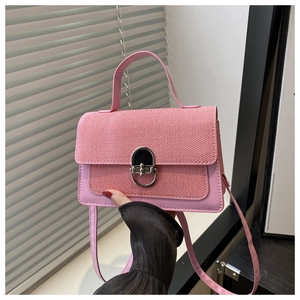 Detail of pink woven texture crossbody bag with oval metal clasp and smooth leather trim