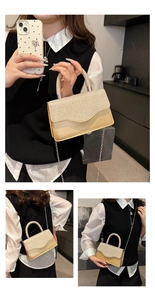 Detail of champagne gold glitter crossbody bag with metal handle and chain strap