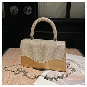 Close-up of sparkling rhinestone evening bag with silver chain on marble surface