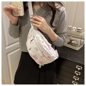 Detail showing white floral chest bag with pink rose print and adjustable strap