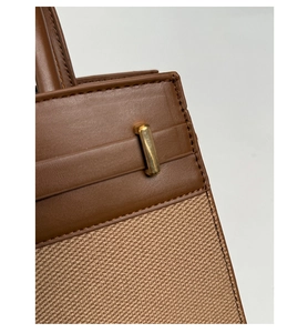 Nahaufnahme von Leinwand und braunem Leder mit eleganter goldener Metallschnalle