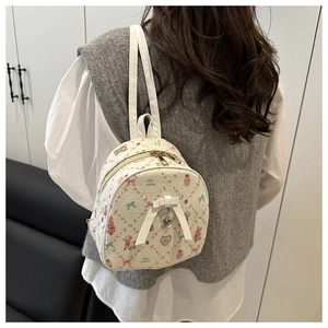 Detail of floral and bear print jacquard mini backpack with a white bow and heart charm