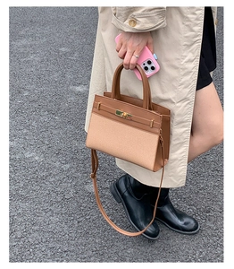 Detailansicht der Canvas-Leder-Tasche mit goldenem Drehverschluss und Nähten