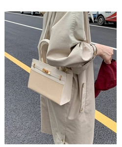 Details der eleganten Tasche aus beigem Canvas mit braunem PU-Leder und Gold-Drehverschluss