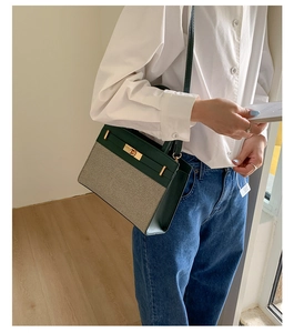 Detail der dunkelgrünen Leder- und khakifarbenen Stofftasche mit Metall-Drehverschluss