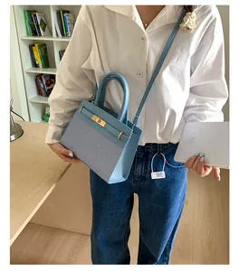 Detailansicht der hellblauen Handtasche mit Canvas-Textur und goldenem Drehverschluss