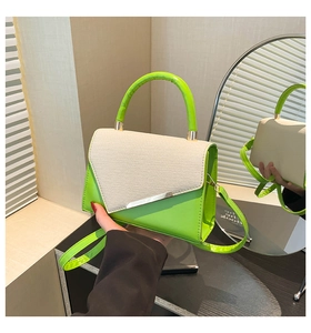 Detail of neon green leather handbag with beige woven flap and metallic silver trim