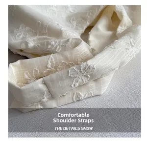 Détail d'une bandoulière confortable avec broderie florale et tissu à texture grillagée