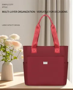 Detail of burgundy oxford fabric tote bag with silver logo and functional side pockets