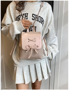Detailaufnahme des rosa PU-Leder-Minirucksacks mit dekorativer Schleife und Kettenriemen
