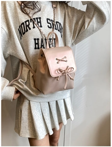 Detail des rosa-beigen Lederrucksacks mit Schleife und Metallketten-Schultergurten