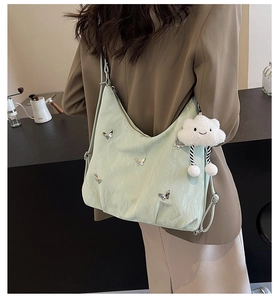 Detail of mint green hobo bag with silver butterflies and cute cloud plush charm