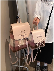 Detailvergleich großer und kleiner Plüschrucksäcke mit Karomuster und rosa Schleifen