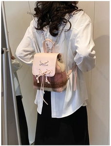 Detail eines rosa karierten Mini-Rucksacks mit Lederschleife und Schnürung am Model