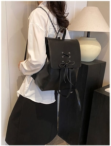 Detail eines schwarzen PU-Lederrucksacks mit Schnürschleife und Metallkettenriemen