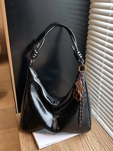 Sac hobo chic en cuir huilé noir avec bandoulière nouée et pendentif métallique