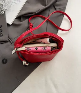 Detail van rode lederen crossbodytas met weergave van de ruime interne capaciteit