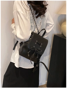 Detailansicht eines Mini-Rucksacks in Schwarz mit Schleife und Metallkette