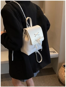 Detailansicht weißer Mini-Rucksack aus Leder mit Kettenriemen und Schleifenverzierung