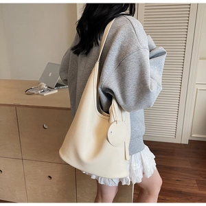 Detail of off-white lychee pattern bucket bag showing capacity and shoulder drape