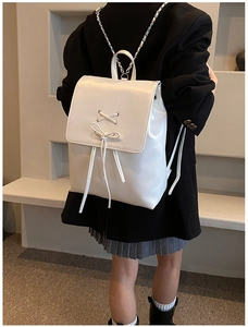 Detailansicht eines weißen Lederrucksacks mit stilvollem Schnürbogen und Klappendesign