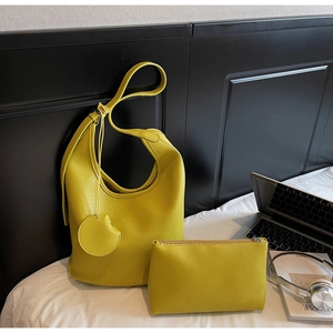 Detailed shot of yellow litchi grain hobo bucket bag with matching zipper pouch