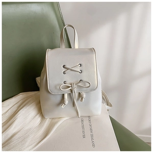 Detail eines minimalistischen cremeweißen Mini-Rucksacks aus PU-Leder mit Schleifenverschluss