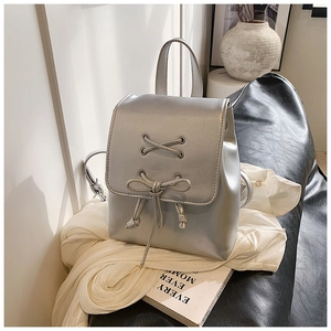 Detail eines silbernen Metallic-Minirucksacks mit Kordelzugschleife und Griff