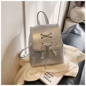 Detail eines silbernen PU-Rucksacks mit schicker Bandschleife und Kordelzugverschluss