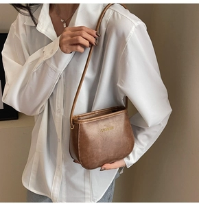 Dettaglio borsa a tracolla vintage in pelle PU marrone con trama a pieghe e logo dorato