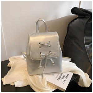 Detail eines silbernen Metallic-Minirucksacks mit Schleifendekor und poliertem Griff