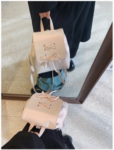 Details des hellrosa Rucksacks im College-Stil mit Schnürung, Schleife und Lederstruktur