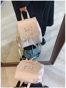 Detailansicht eines rosa Lederrucksacks mit Schleife und Spiegelreflexionseffekt