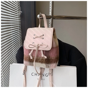 Detailaufnahme des kleinen Plüsch-Rucksacks mit rosa Karomuster und Leder-Schleife