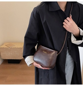 Dettaglio della borsa a tracolla in pelle PU marrone scuro con logo dorato YUSHAN