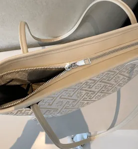 Macro view of smooth silver metal zipper and textured geometric pattern on tote bag