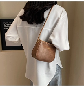 Borsa a spalla in pelle PU marrone con logo dorato indossata sulla schiena