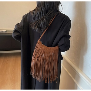 Detail of brown suede hobo bag with long fringes and bohemian vintage texture