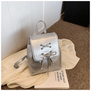 Detailaufnahme des silbernen Metall-Rucksacks mit Kordelzug und Schleifendekoration