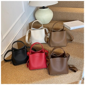 Détail de mini sacs seaux en plusieurs couleurs avec texture en cuir grainé élégante