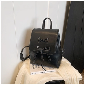 Detail eines schwarzen Mini-Rucksacks aus Kunstleder mit Zierschnürung und Kordelzugverschluss