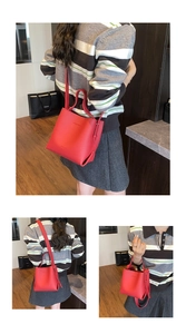 Détails du sac seau en cuir rouge avec texture grainée et bandoulière amovible