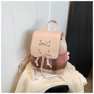 Detailaufnahme des rosa karierten Plüschrucksacks mit Schleife auf dem Lederdeckel