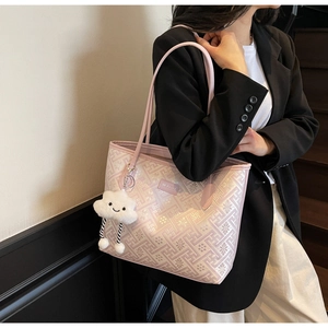Close-up of pink jacquard tote bag featuring geometric patterns and a plush cloud charm