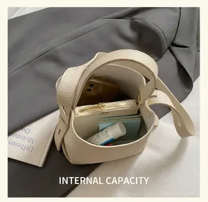 Vue de l'intérieur du sac seau crème montrant le téléphone et le portefeuille