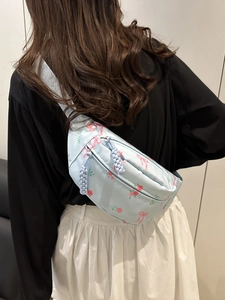 Floral print crossbody chest bag in light blue with pink rose patterns and adjustable strap