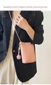 Pink lychee texture crossbody phone bag with handmade woven charm worn by a model