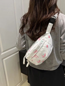 Floral print waist bag with pink bows and white strap shown on model back