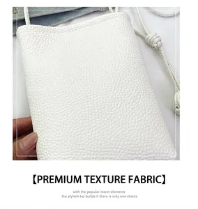 Close-up of white lychee pattern leather mini bucket bag with slender shoulder strap